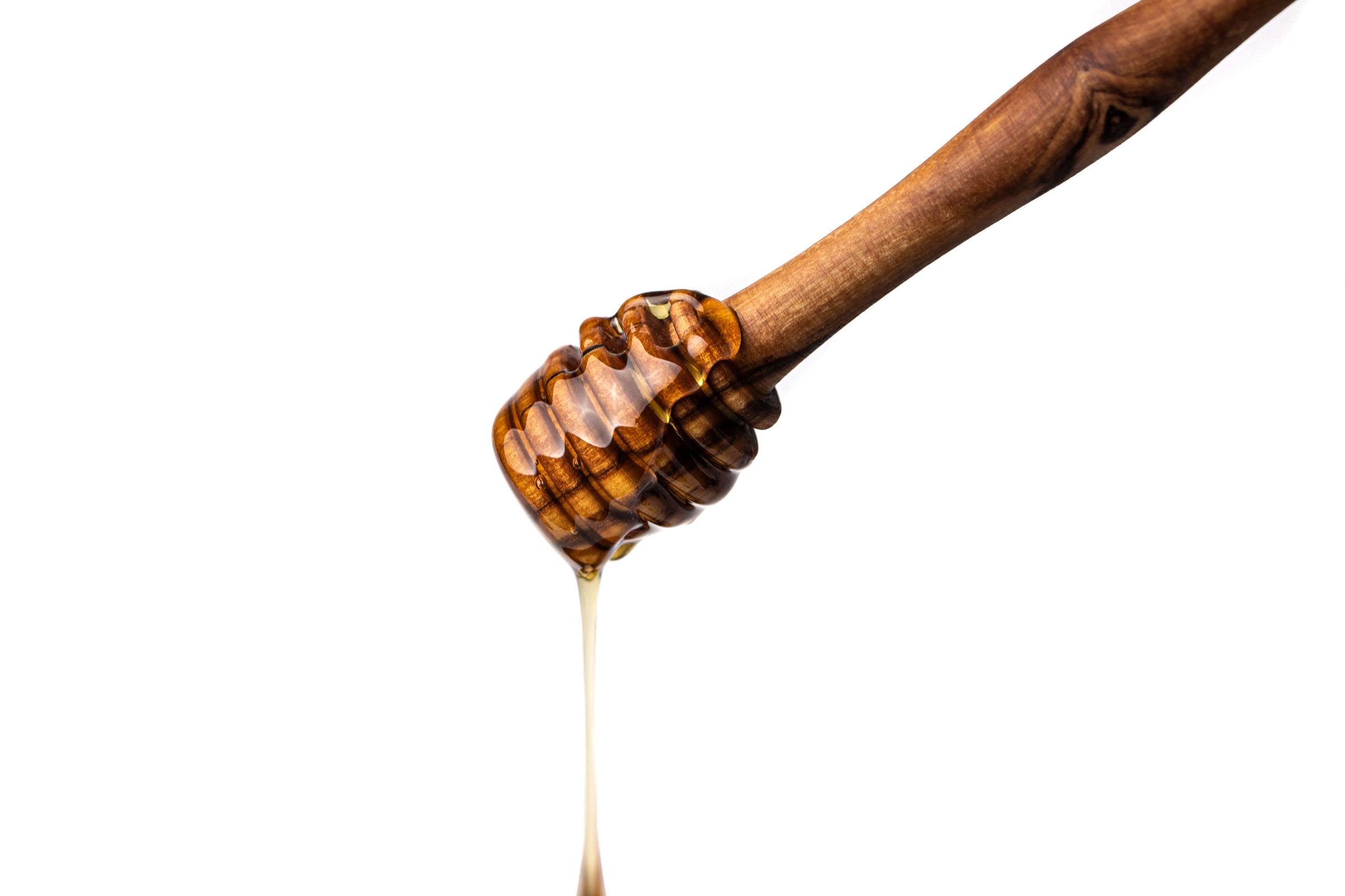Honiglöffel aus Olivenholz mit tropfendem Honig